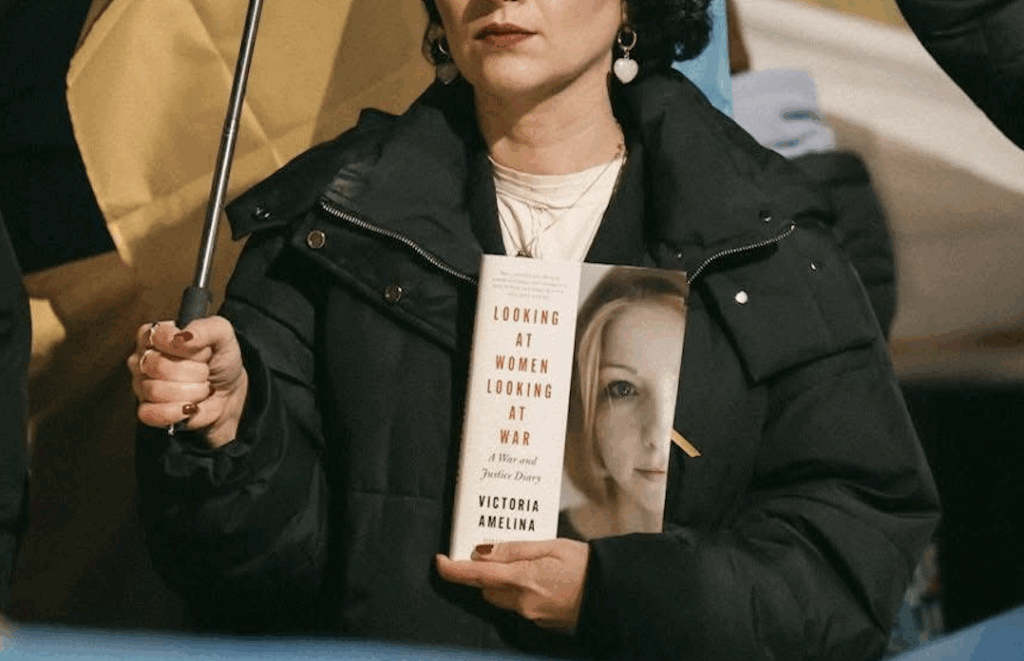 Gvantsa Jobava holding Victoria Amelina's book "Looking at Women Looking at War" Credit Levan Zazadze